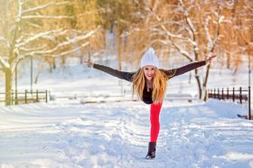 Kobieta ćwiczy jogę w zimowym otoczeniu
